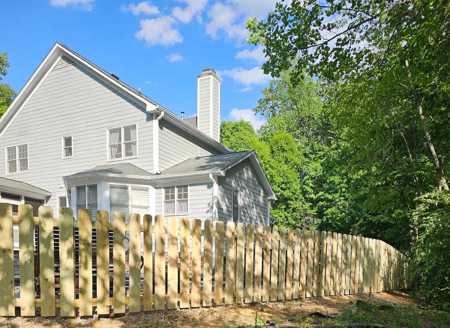 Completed post-and-rail fence with a wood gate