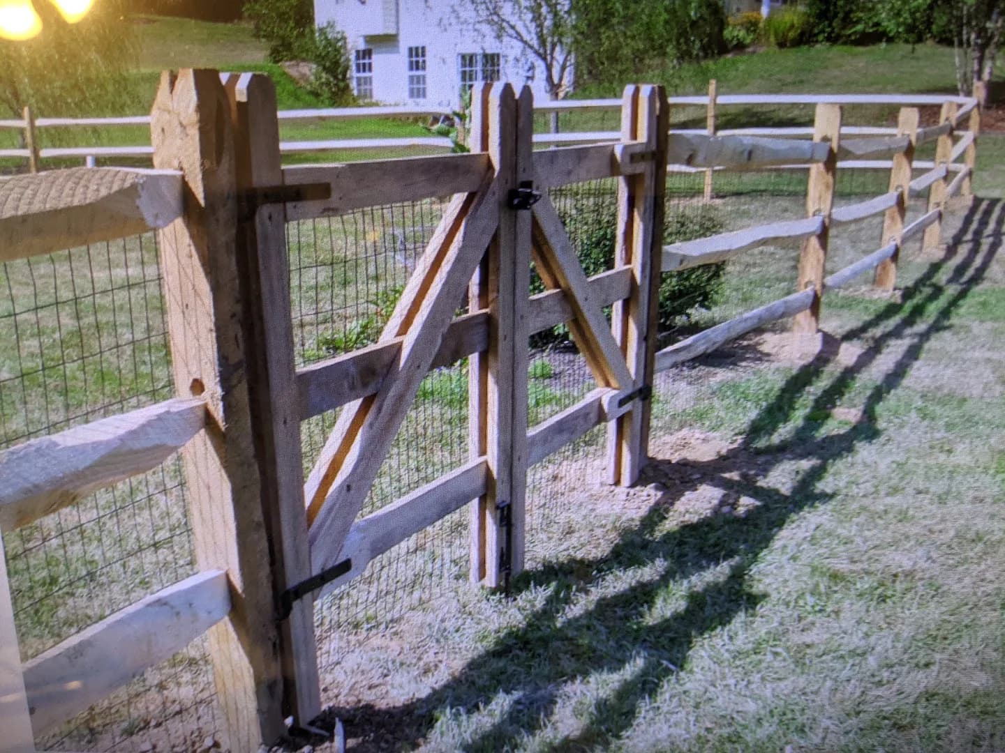 Completed post-and-wire fence with double wood gates