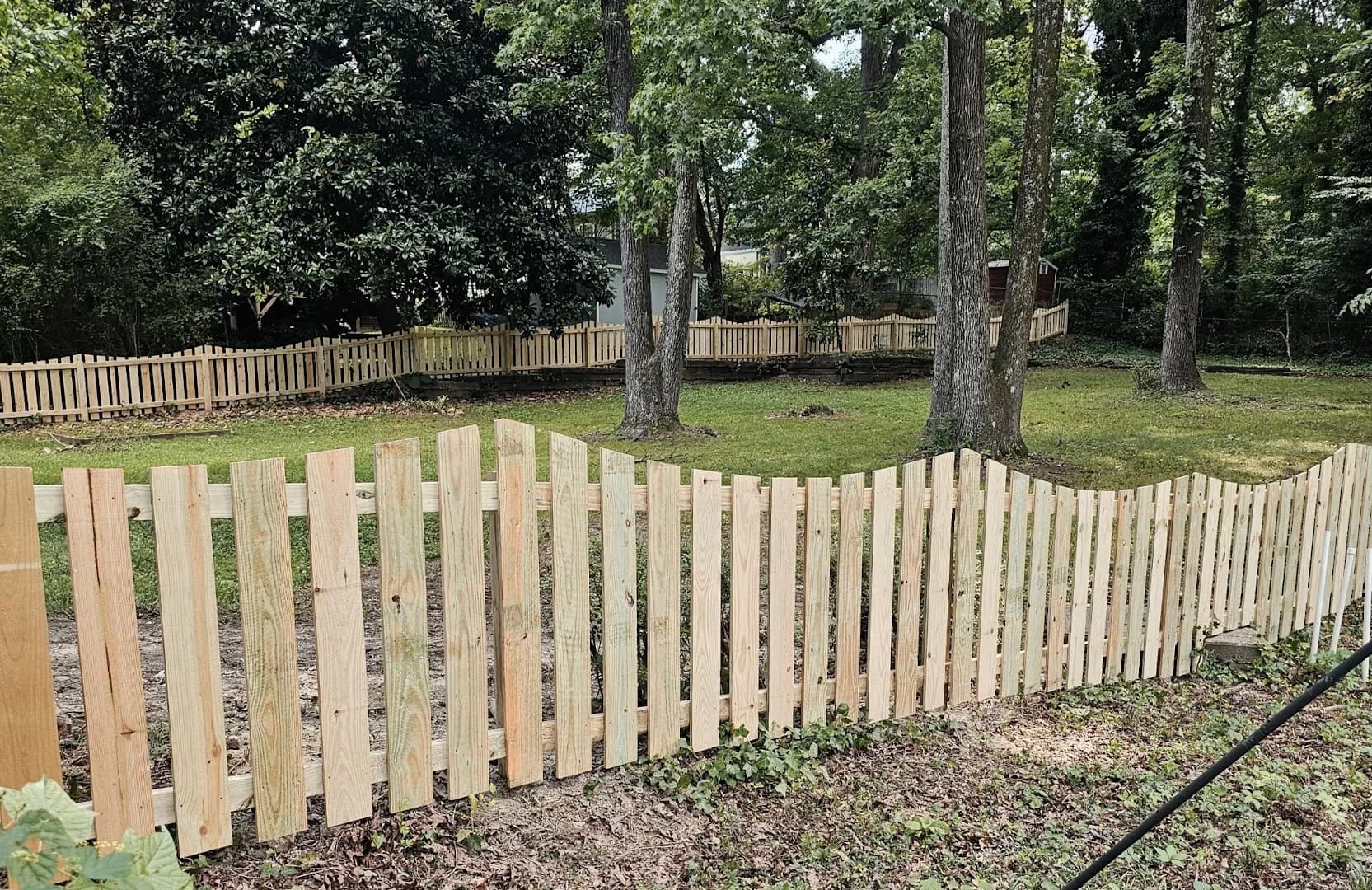 Completed wood picket fence with matching double gates