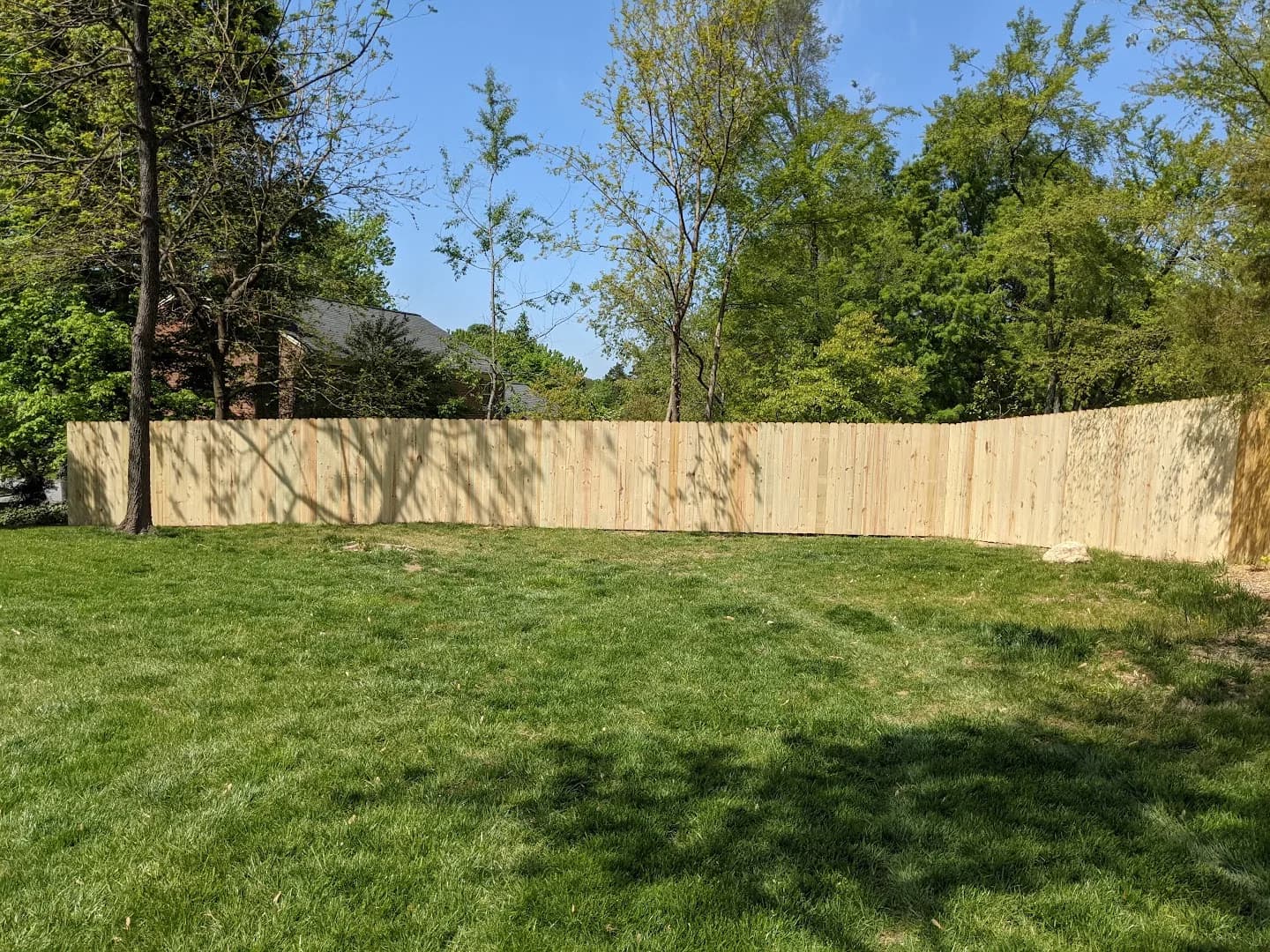 Completed wood privacy fence enclosing a backyard