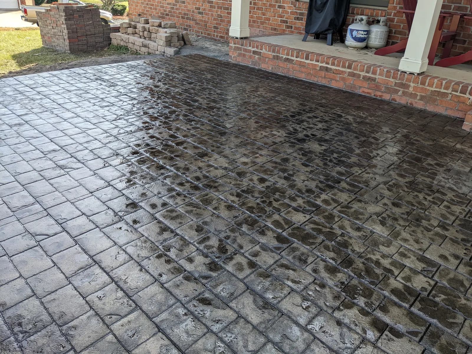 Wet-sealed stamped concrete patio in a two-tone cobblestone pattern