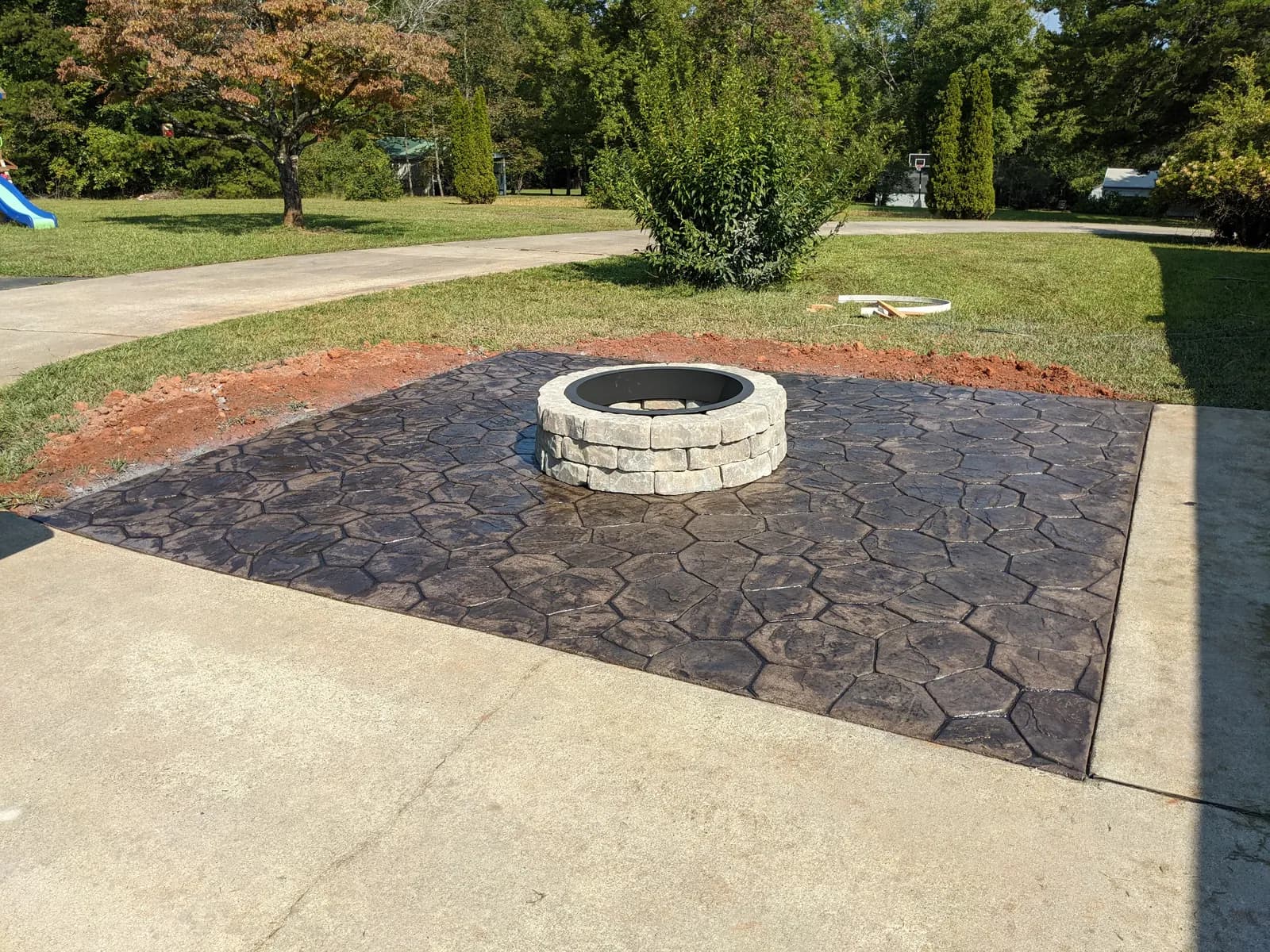 Charcoal random-stone stamped patio with stone fire pit