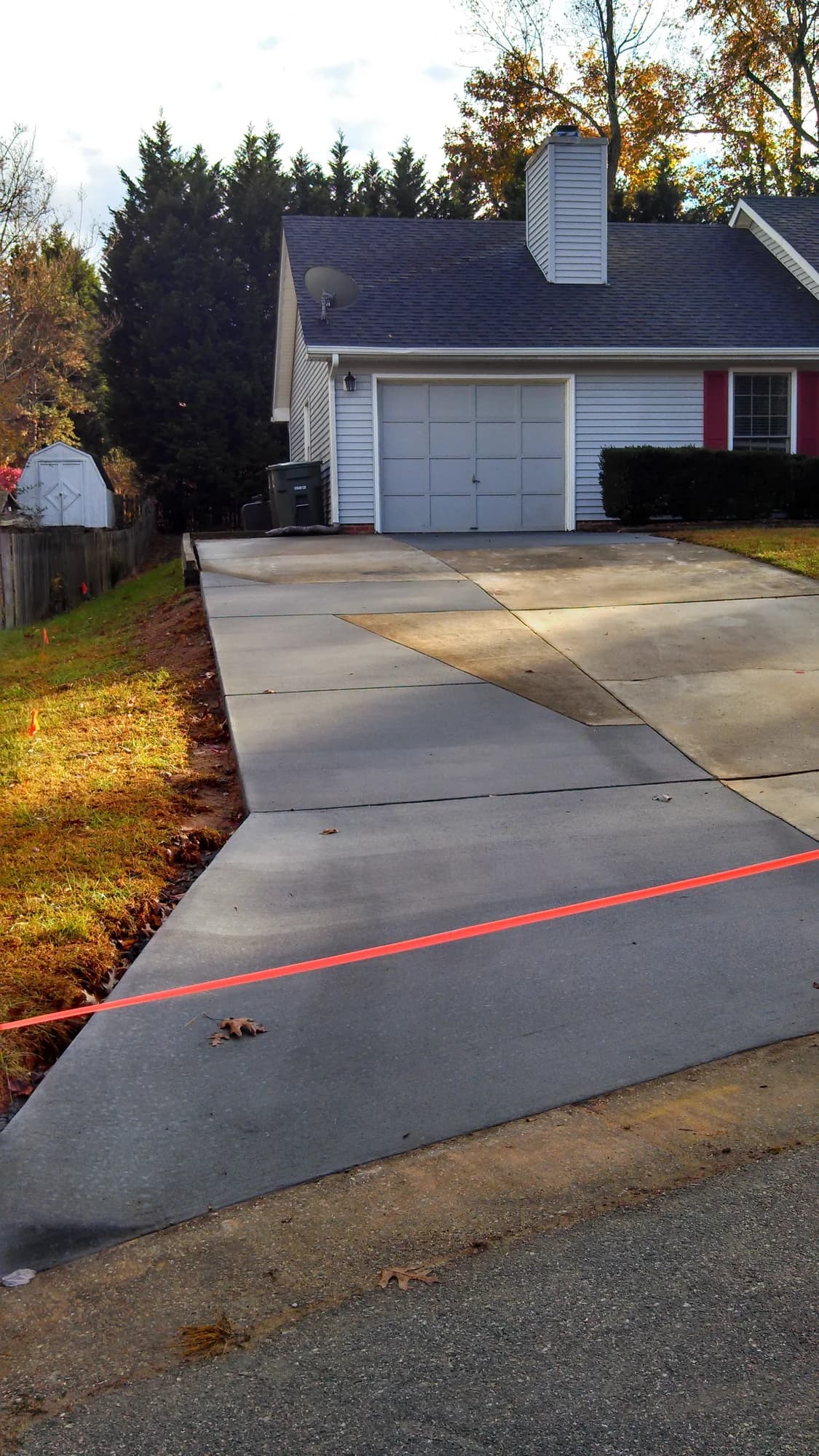 Concrete driveway leading uphill to a detached garage