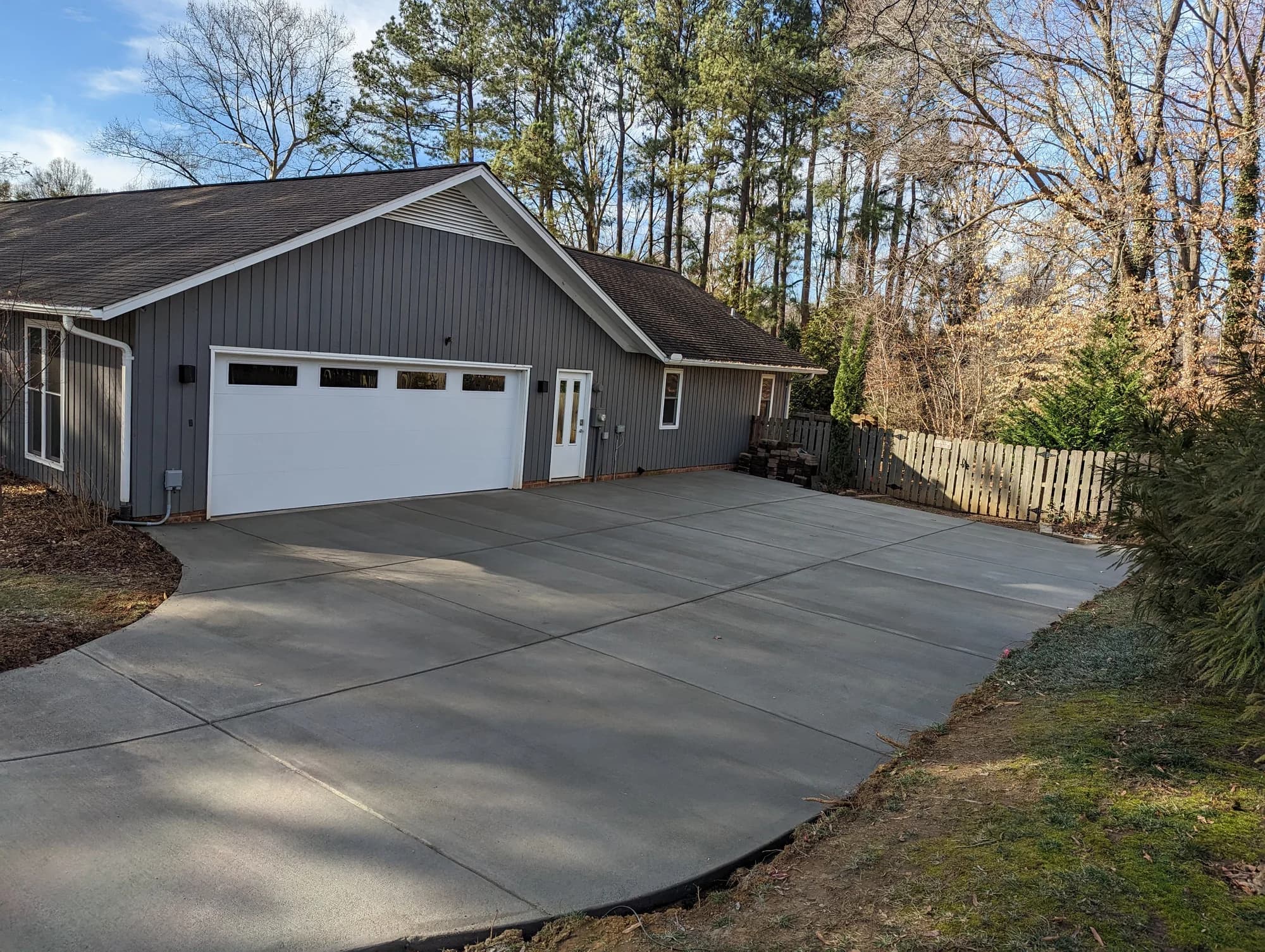 Wide concrete driveway and parking area in front of a detached garage