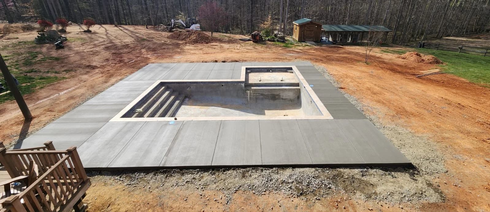Concrete pool deck surrounding a rectangular pool and raised spa