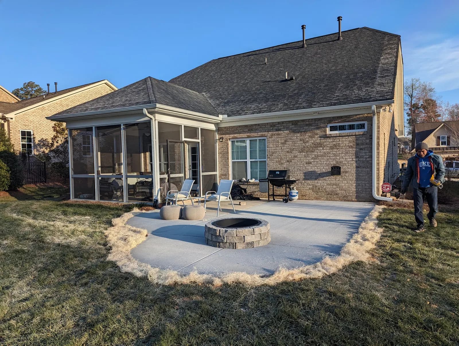 Concrete patio with stacked-stone fire pit at golden hour