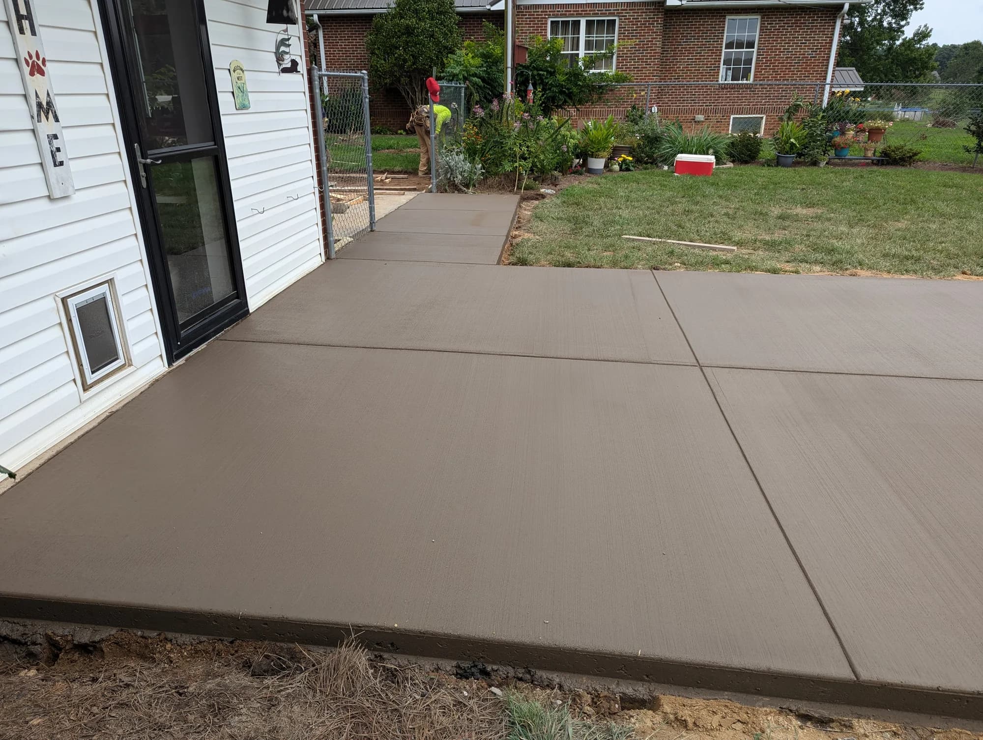 Fresh broom-finished concrete patio outside a back door