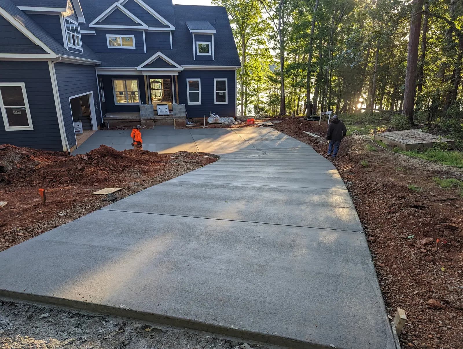 Long broom-finished driveway at a new-construction lake house