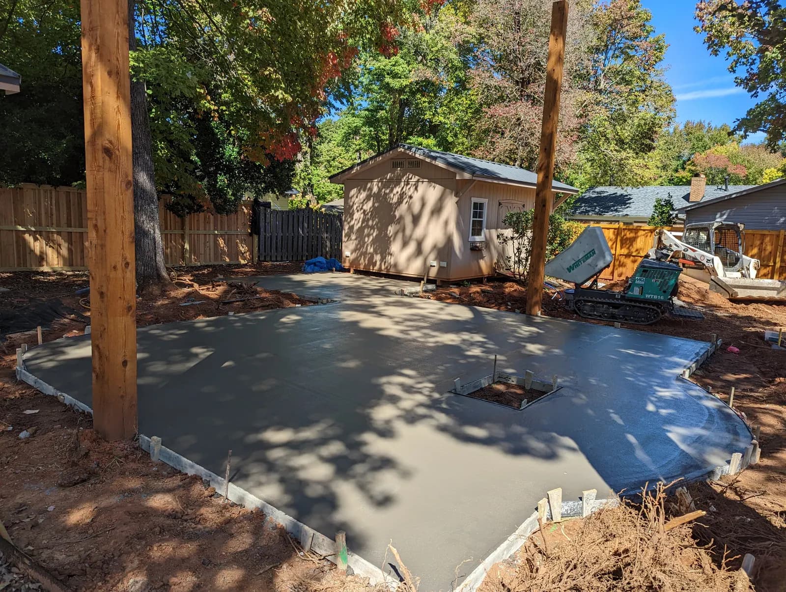 Broom-finished patio poured around pergola posts