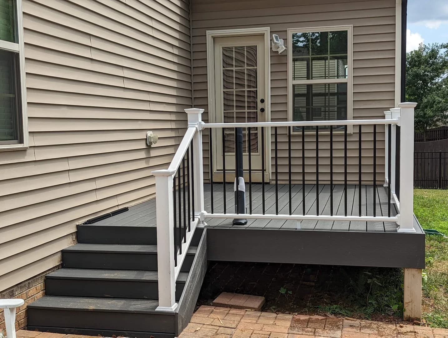 Completed gray composite deck beside an above-ground pool