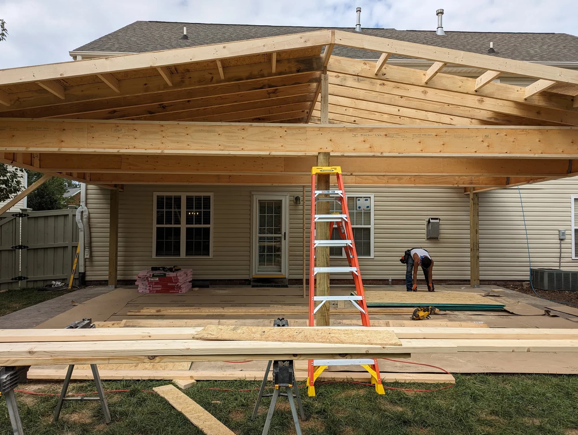 Patio cover roof and post framing during construction