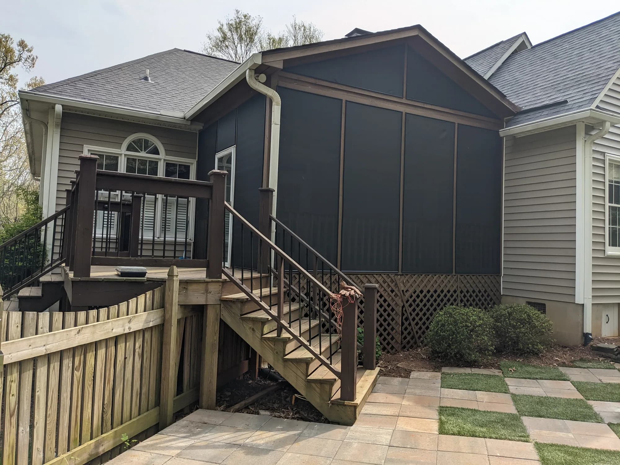 Finished dark screened porch attached to the back of a home