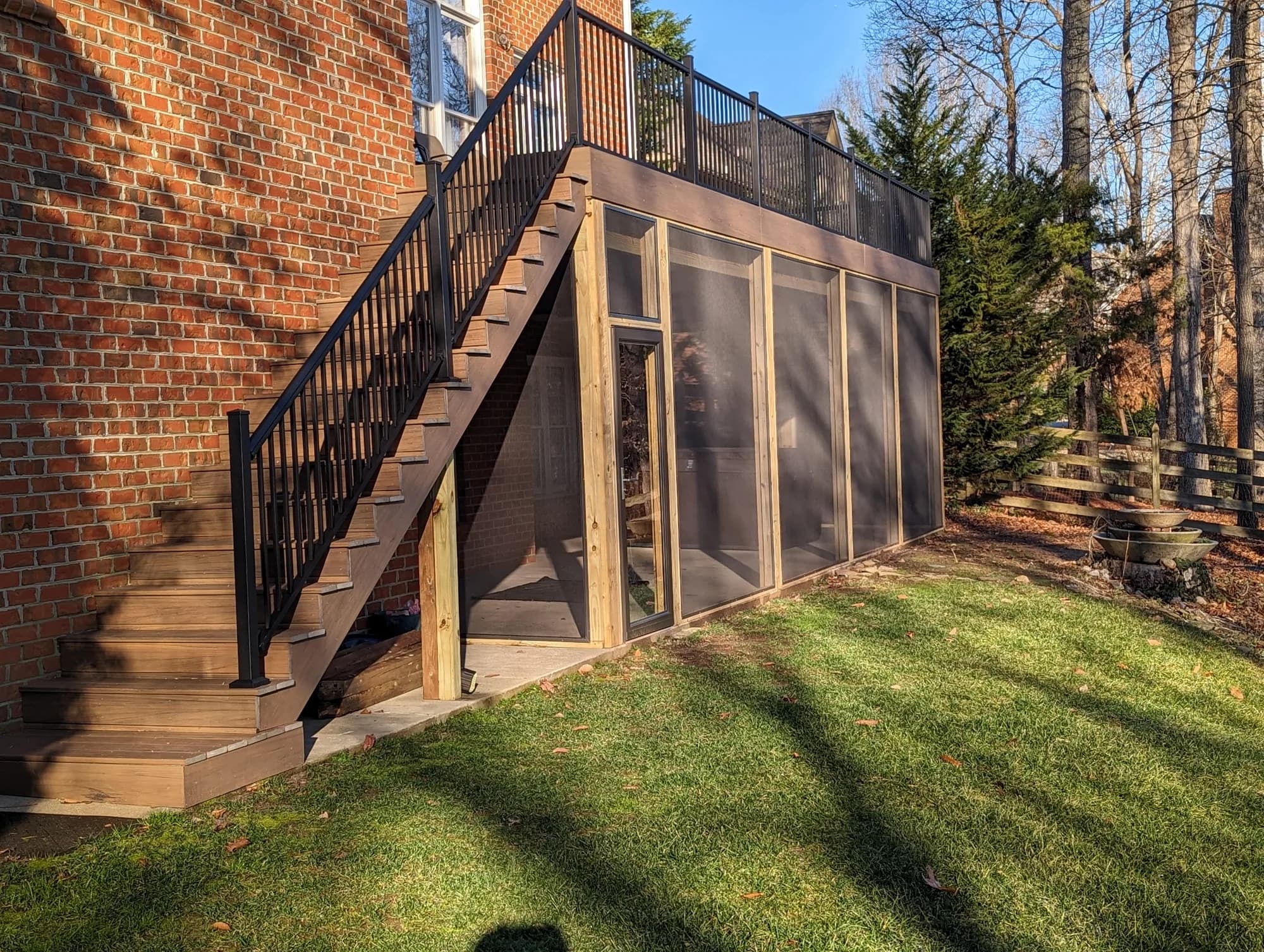Screened room built beneath an elevated deck with an exterior staircase