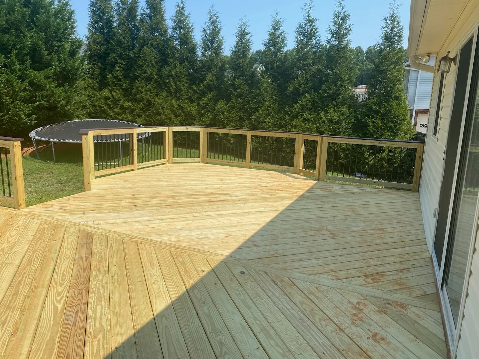 Completed wood deck with black metal balusters