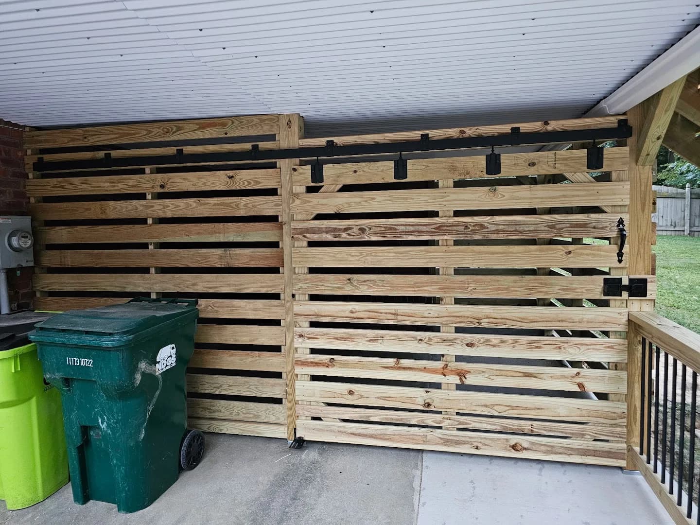 Completed wood deck with black balusters and access to a backyard pool