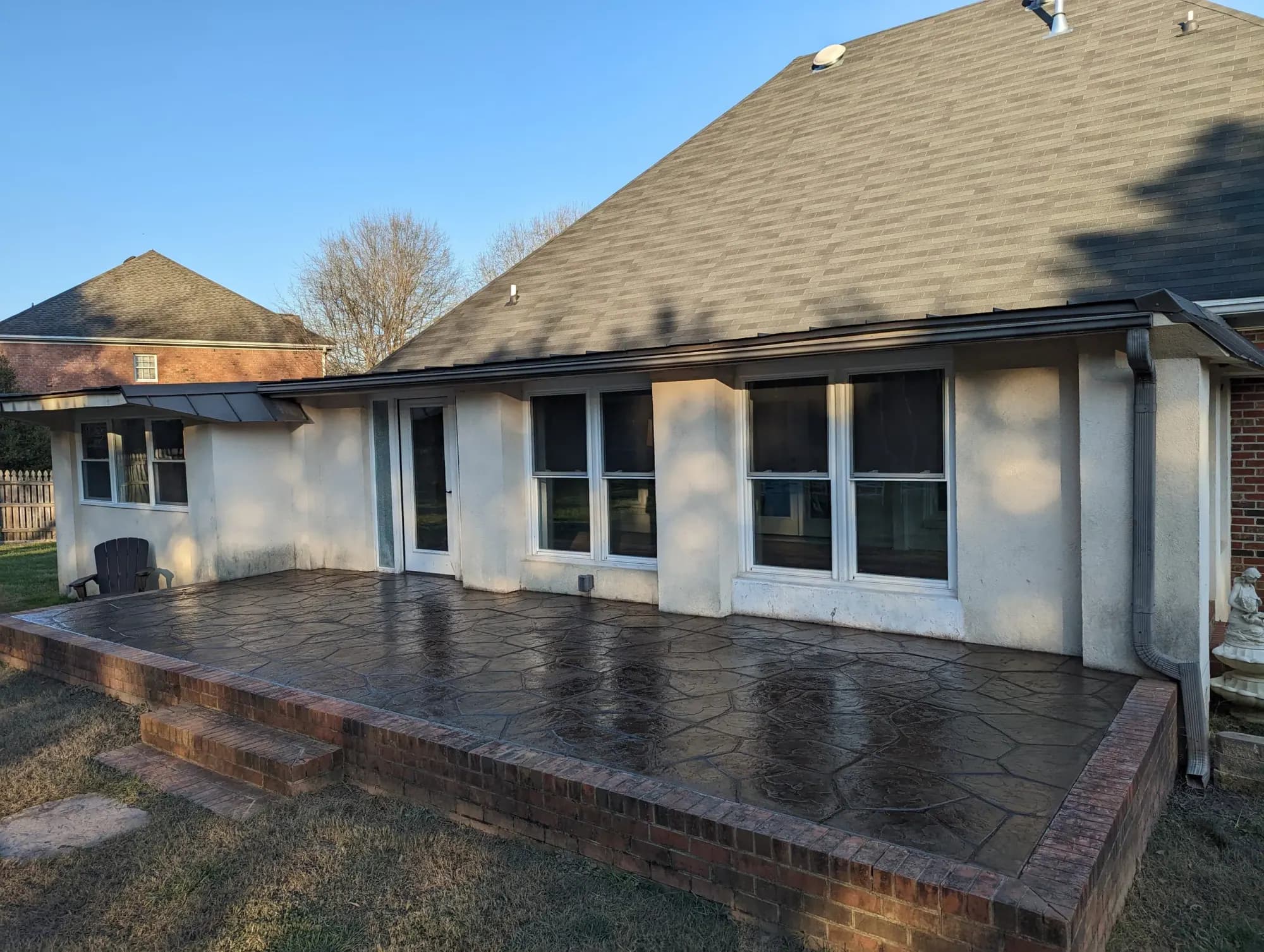 Raised large flagstone stamped concrete patio in buff with dark gray release, High Point, NC