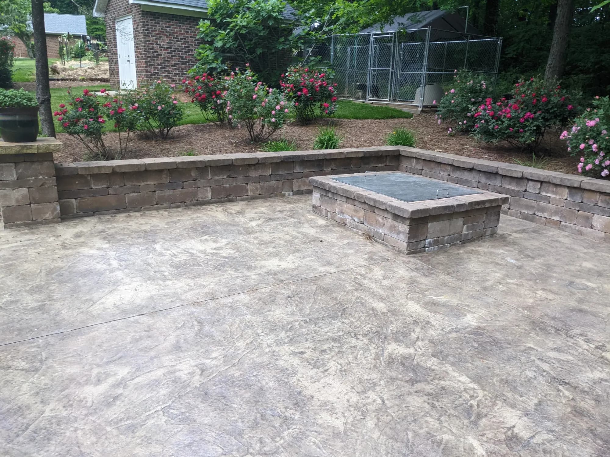 Stamped concrete patio with a fire pit and stone seating wall in High Point, NC